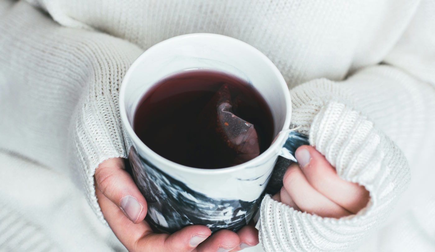 holding mug of tea